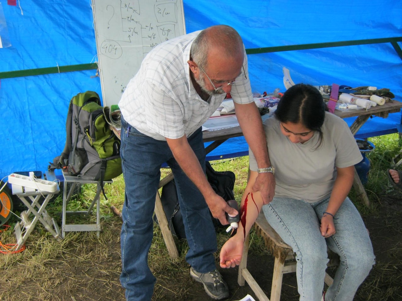Applying fake blood to make learning how to dress wounds more life-like.